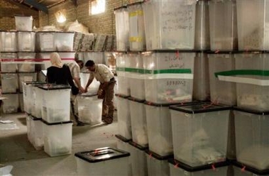 Iraqi referendum officials handle ballot boxes before counting the votes in Baqouba, Iraq, Sunday, Oct. 16 2005.