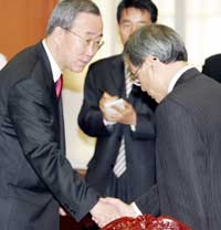 South Korea's Foreign Minister Ban Ki-moon (L) shakes hands with Japanese Ambassador to South Korea Oshima Shotaro at the Ban's office in Seoul October 17, 2005. South Korea has expressed strong regret at Japanese Prime Minister Junichiro Koizumi's visit to a war shrine on Monday and summoned Shotaro to protest against the move.