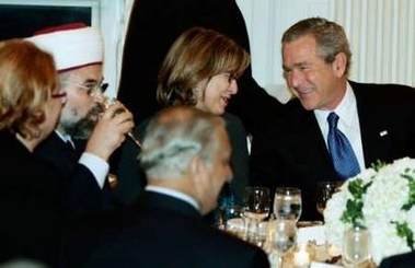 U.S. President George W. Bush (R) shares a light moment with guests including Imam Talal Eid (2nd-L) at an Iftar dinner with ambassadors and Muslim leaders in the State Dining room of the White House in Washington, October 17, 2005.