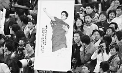 A Liu Xiang fan holds a portrait of the Olympic champion hurdler during the 110m hurdles preliminaries of the 10th National Games on Wednesday at the Nanjing Olympic Stadium. Liu easily won the gold medal with a time of 13.10 seconds yesterday. 