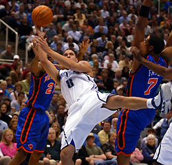 tah Jazz guard Deron Williams sends an off-balance shot off while being double-teamed by New York Knicks defenders Trevor Ariza (L) and Channing Frye (R) during the second half of NBA action in Salt Lake City November 14, 2005. 