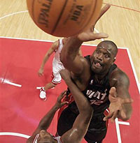 Miami Heat center Shaquille O'Neal (R) shoots over Chicago Bulls forward Michael Sweetney (bottom) during the first half of their NBA game in Chicago December 13, 2005. Miami Heat won the game 100-97.