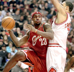 Cleveland Cavaliers' LeBron James, left, makes a pass under the basket around Chicago Bulls defender Tyson Chandler, right, during the first quarter.