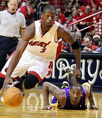 Los Angeles Lakers guard Kobe Bryant (R) watches Miami Heat guard Dwyane Wade drive to the basket during their NBA game in Miami, Florida December 25, 2005.