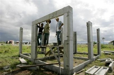 Acehnese workmen fit prefabricated cement building blocks together to frame a house in an International Organization for Migrants (IOM) project Tuesday, Dec. 27, 2005 in Cot Paya village outside Banda Aceh, Indonesia.