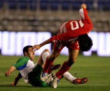 China's Li Yi (R) and autonomous region of Andalucia's Carlos Marchena fight for the ball during their friendly soccer match at the Ramon de Carranza Stadium in Cadiz, southern Spain, December 28, 2005.