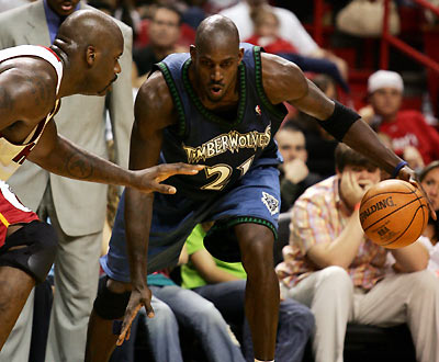 Miami Heat center Shaquille O'Neal (L) defends Minnesota's Wolves forward Kevin Garnett during NBA action in Miami, Florida January 1, 2006. 
