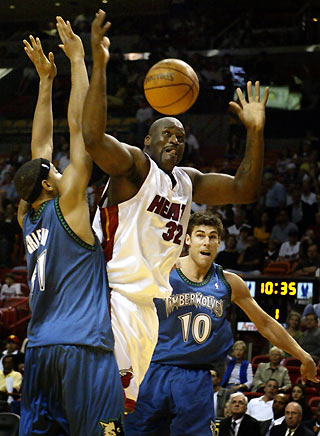 Miami Heat center Shaquille O'Neal (C) is defended by Minnesota's Wolves Eddie Griffin (L) and Wally Szczerbiak (R) during NBA action in Miami, Florida January 1, 2006.