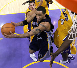Memphis Grizzlies Damon Stoudamire (C) goes up for a shot past Los Angeles Lakers Sasha Vujacic (L) and Kwame Brown during their NBA game in Los Angeles December 28, 2005. Memphis won 100-99 in overtime, and Stoudamire was Memphis' highest scorer with 25 points.