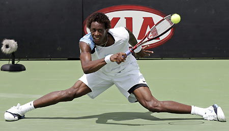 Gael Monfils of France hits a return against Luis Horna of Peru during the Australian Open tennis tournament in Melbourne January 17, 2006.[Reuters]