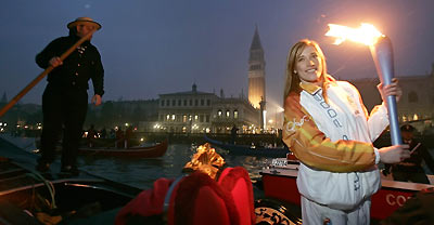 Italian runner Manuela Levorato carries the Olympic torch in a gondola past St. Marco square in Venice January 17, 2006.