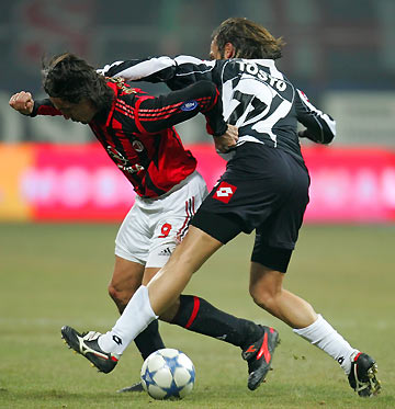 AC Milan's Filippo Inzaghi (L) is tackled by Ascoli's Vittorio Tosto during their Italian Serie A soccer match at the San Siro stadium in Milan January 18, 2006. [Reuters]