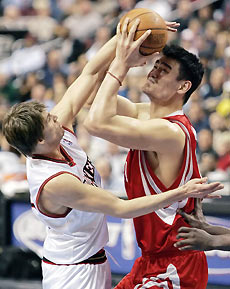 Houston Rockets center Yao Ming (R) is fouled by Philadelphia 76ers forward Kyle Korver during second quarter NBA action in Philadelphia February 6, 2006. 