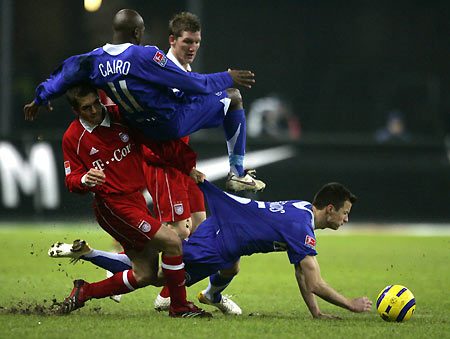 FC Bayern Munich's Philipp Lahm (L) and team mate Bastian Schweinsteiger (2nd R) tackle Hertha Berlin's Ellery Cairo and Vaclav Sverkos (R) during their German first division Bundesliga soccer match in Berlin February 7, 2006. [Reuters]