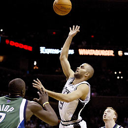 San Antonio Spurs guard Tony Parker (C) goes to the hoop against Dallas Mavericks center DeSagana Diop (L) and forward Keith Van Horn in the first half during their NBA game in San Antonio, Texas, March 2, 2006. 