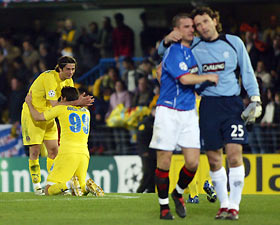 Villarreal's players Alessio Tacchinardi of Italy (L) celebrates with his team mate Guillermo Franco of Mexico in front of Ranger's goalkeeper Ronald Waterreus of Holand (R) and Barry Ferguson (C) at the end of their Champions League first knockout round second leg soccer match at Villarreal's Madrigal stadium March 7, 2006.