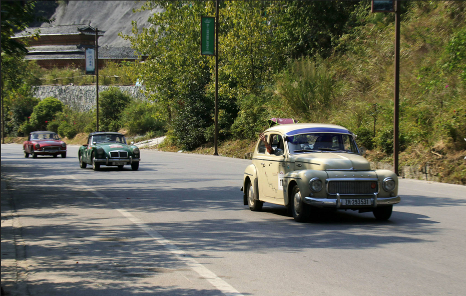 Fleet of vintage cars arrives in Zhaoxing Dong village, Guizhou province during cross-country trip