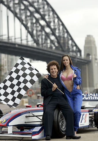 Entertainer Leo Sayer and model Serena Brimicombe pose with a Formula One race car near the Sydney Harbour Bridge March 20, 2006. Sayer, enjoying a career resurgence with the remix of his 1970s hit "Thunder in My Heart" in Britain, will be part of the Australian Formula One Grand Prix Ball ahead of the Australian Formula One race which will take place April 2, 2006. [Reuters]
