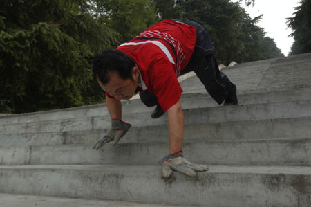 A Chinese man named Xing Hui climbs down the steps at a park in Xiangfan, central China's Hubei Province, June 20, 2006. Xing Hui, 41-year-old, likes boxing, swimming, and wrestling, but these exercises do little help to his neck suffering from pain for a long time. Half a year ago, Xing Hui began to practice climbing down the steps, and now his neck is fine, sources said. [newsphoto]