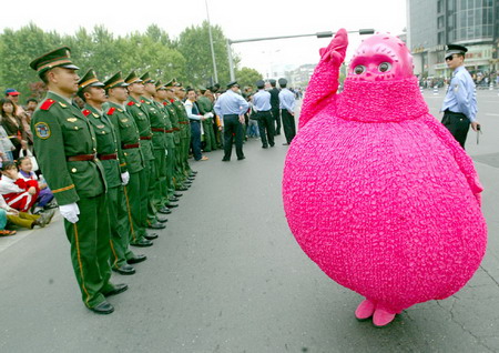 Soldiers stand guard as a worker dressed as a cartoon greets visitors during a cartoon show in Hangzhou, East China's Zhejiang Province, April 27, 2006. [Han Dan/Metro Express]