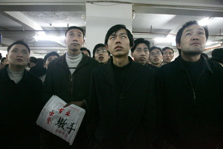 Migrant workers look for job opportunities at a labor market in Southwest China's Chongqing, May 18, 2006. [Wang Yuanling/Chongqing Times]