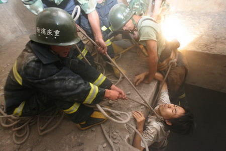 Firemen rescue Liu Jie, who was trapped in a bridge abutment for 26 hours, in ChongqingJuly 16, 2006. Liu Jie fell into the abutment by accident and attracted people's attention by setting on his clothes on fire with a lighter. [Wang Yuanling/Chongqing Times]