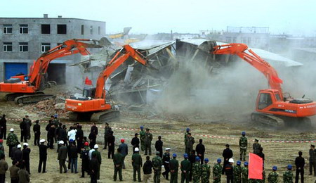 Law enforcement officials watch as illegal buildings are destroyed in Harbin, Northeast China's Heilongjiang Province, April 30, 2006. [Chen Nan/Harbin Daily]