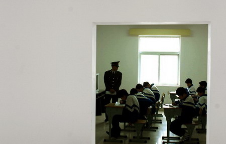 A military official supervises students as they study in a classroom during military training in Changsha, Central China's Hunan Province in April 2006. [Zhu Huifeng/Xiaoxiang Morning News]