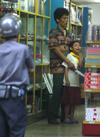 A boy is taken hostage in a shop in Foshan, South China's Guangdong Province, May 11, 2006. The boy was later freed. [Chen Pingsheng/Southern Metropolitan News]