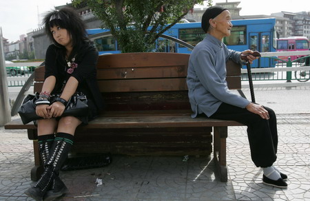 Quan Jingying (right), 18, a university student who studies fashion design, and Li Yu'e, 81, with bound feet, sit on a chair in Xi'an, North China's Shaanxi Province, September 9, 2006. [Deng Xiaowei/Huashang News]