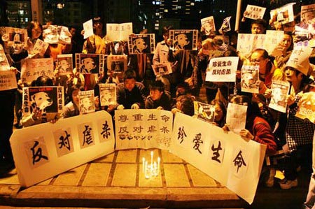  Residents hold a protest over the killing of five puppies by a man in a community in Kunming, Southwest China's Yunnan Province, December 12, 2006. The man was said to have killed the five puppies by stepping on them. The Chinese characters read 