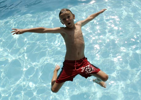 A boy dives into a swimming pool on a hot day in Vienna July 19, 2007. Weather forecast predicts a peak of 38 degrees Celsius (100.4 degrees Fahrenheit) on Friday. [Reuters]