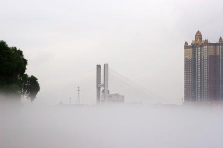 Buildings are seen in heavy fog in Jilin City, Northeast China's Jilin Province, August 12, 2007. [newsphoto]