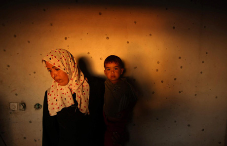 Palestinian woman in damaged house