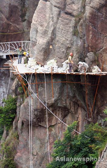 Chinese spider men work on cliffs