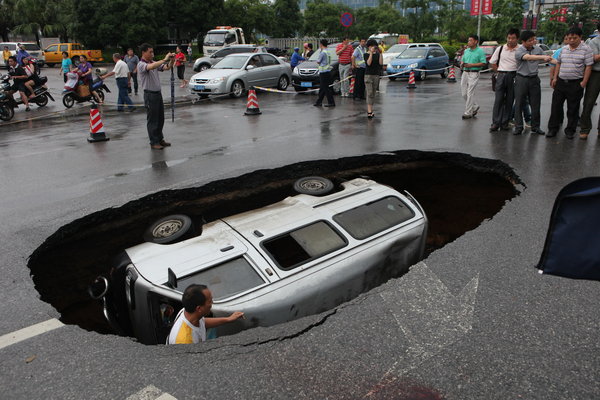 Car falls in as road in S China caves in