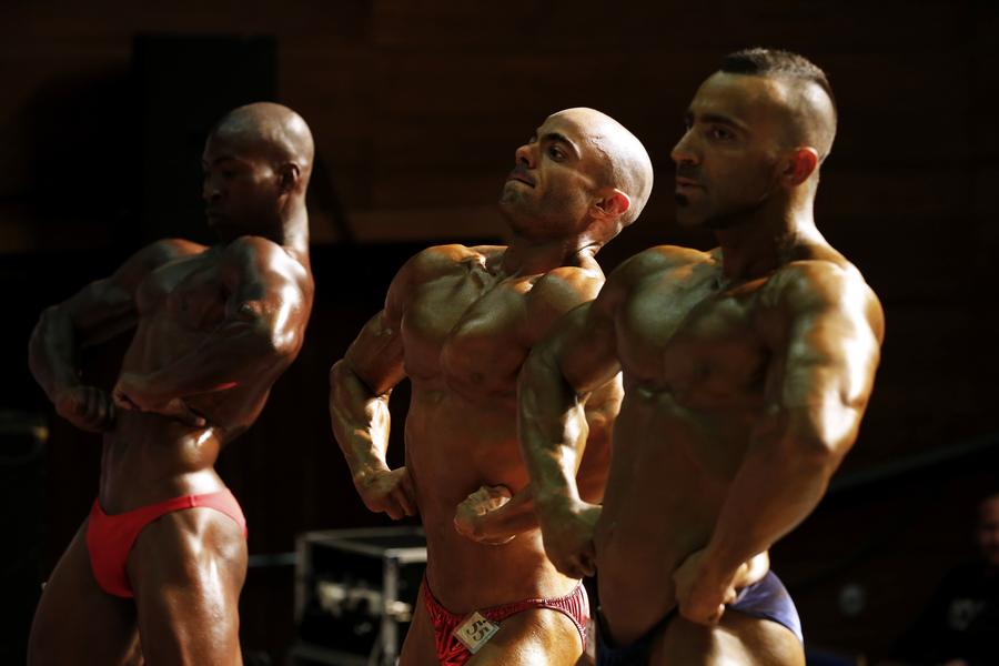 Bodybuilders prepare backstage before competition