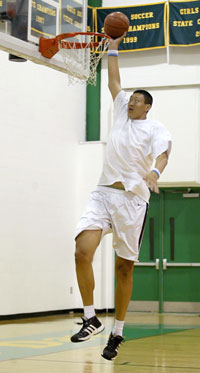 Sun Ming Ming of China, who plays for the United States Basketball League's (USBL) Dodge City Legend, dunks a ball during a workout session in Greensboro, North Carolina, October 6, 2006. At nearly 7 feet 9 inches (2.36 meters) tall and with size 19 feet, Sun dreams of being in the NBA. Picture taken October 6, 2006. 