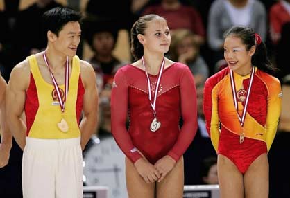 China's gold medallist on the floor Cheng Fei (R) smiles on the podium to her compatriot and gold medallist in the parallel bar event Yang Wei (L) as silver medallist on the floor Jana Bieger of the U.S. looks on at the 39th Artistic Gymnastics World Championships in Aarhus, Denmark, October 21, 2006. 