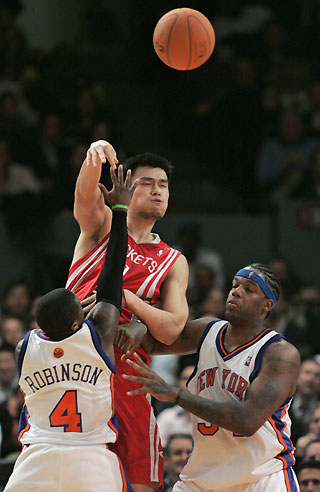 Houston Rockets center Yao Ming (C) pass over New York Knicks guard Nate Robinson (4) and center Eddie Curry in the second period of their NBA basketball game in New York, November 20, 2006. The pass was intercepted by the Knicks Jamal Crawford.