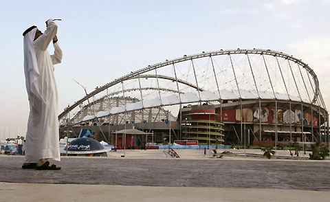 A man takes a picture outside the Khalifa Stadium a day before the start of the 15th Asian Games in Doha November 30, 2006. 