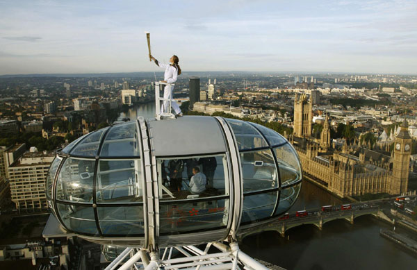 Torch bearer stands on top of London Eye