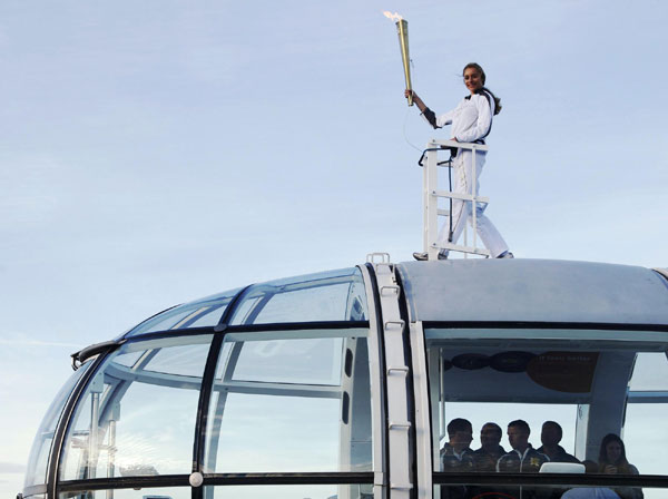Torch bearer stands on top of London Eye