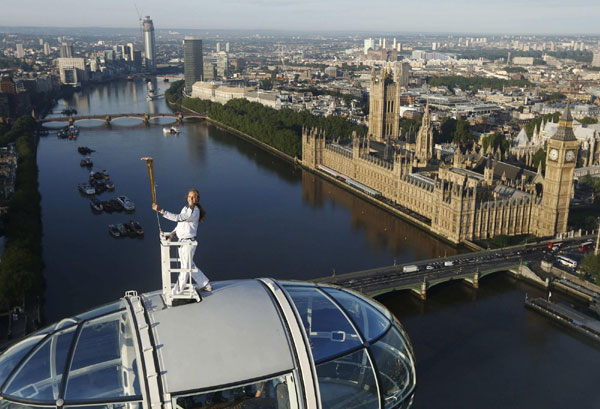 Torch bearer stands on top of London Eye
