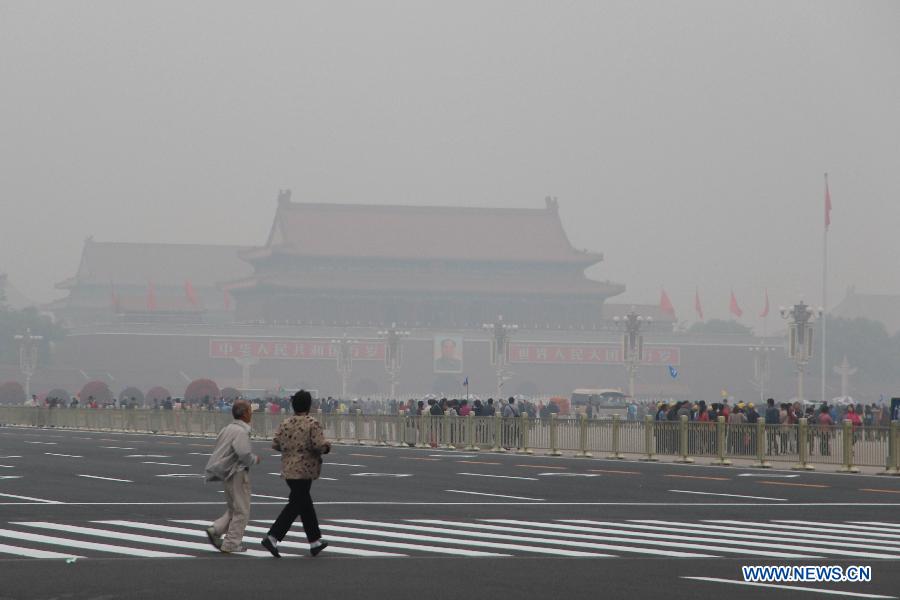 Tourists visit smog-enveloped Tian'anmen Square in Beijing