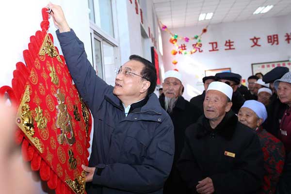 Premier Li takes Spring Festival greetings, and gifts, to old folk