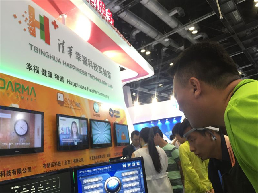 A visitor listens to an audio broadcast at the stand of Happiness Science Lab at Tsinghua University