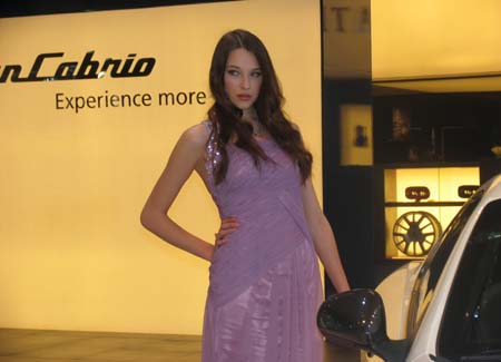 Model poses next to a Maserati car