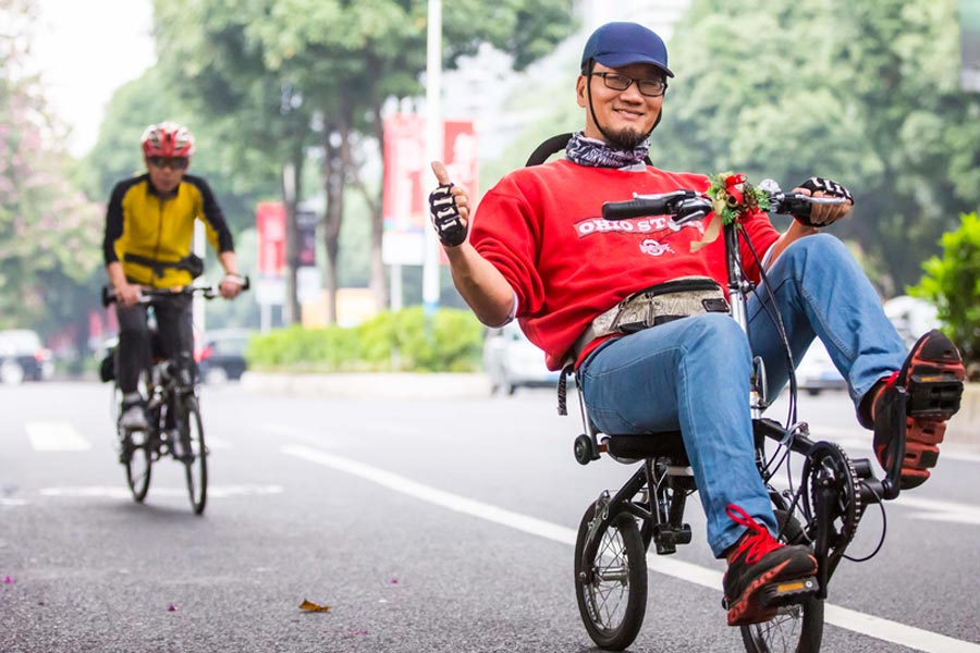 Cyclists sit back as they pedal through Guangzhou