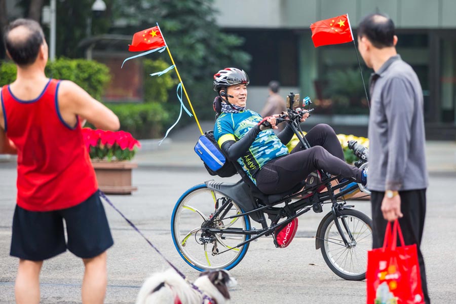 Cyclists sit back as they pedal through Guangzhou